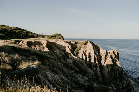 Lighthouse on a rocky coastal headland by the ocean