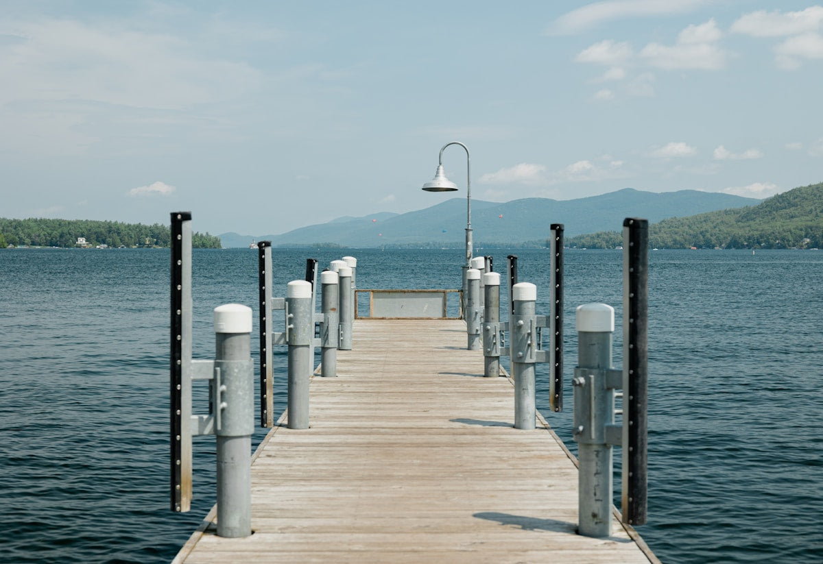 Wide empty pier stretching over calm spring water