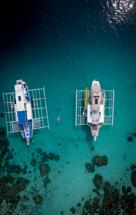 Aerial of boats over turquoise reef water